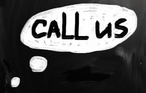 "Call us" handwritten with white chalk on a blackboard